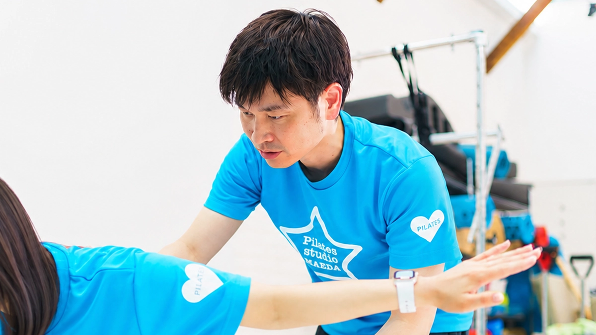 男性インストラクターが女性の指導をしている様子。